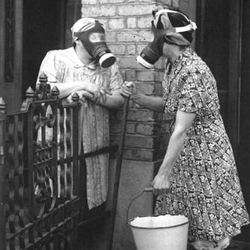 The outbreak of World War II saw gas masks become ubiquitous in life 1940s Gas Mask Housewife Chatting over a fence